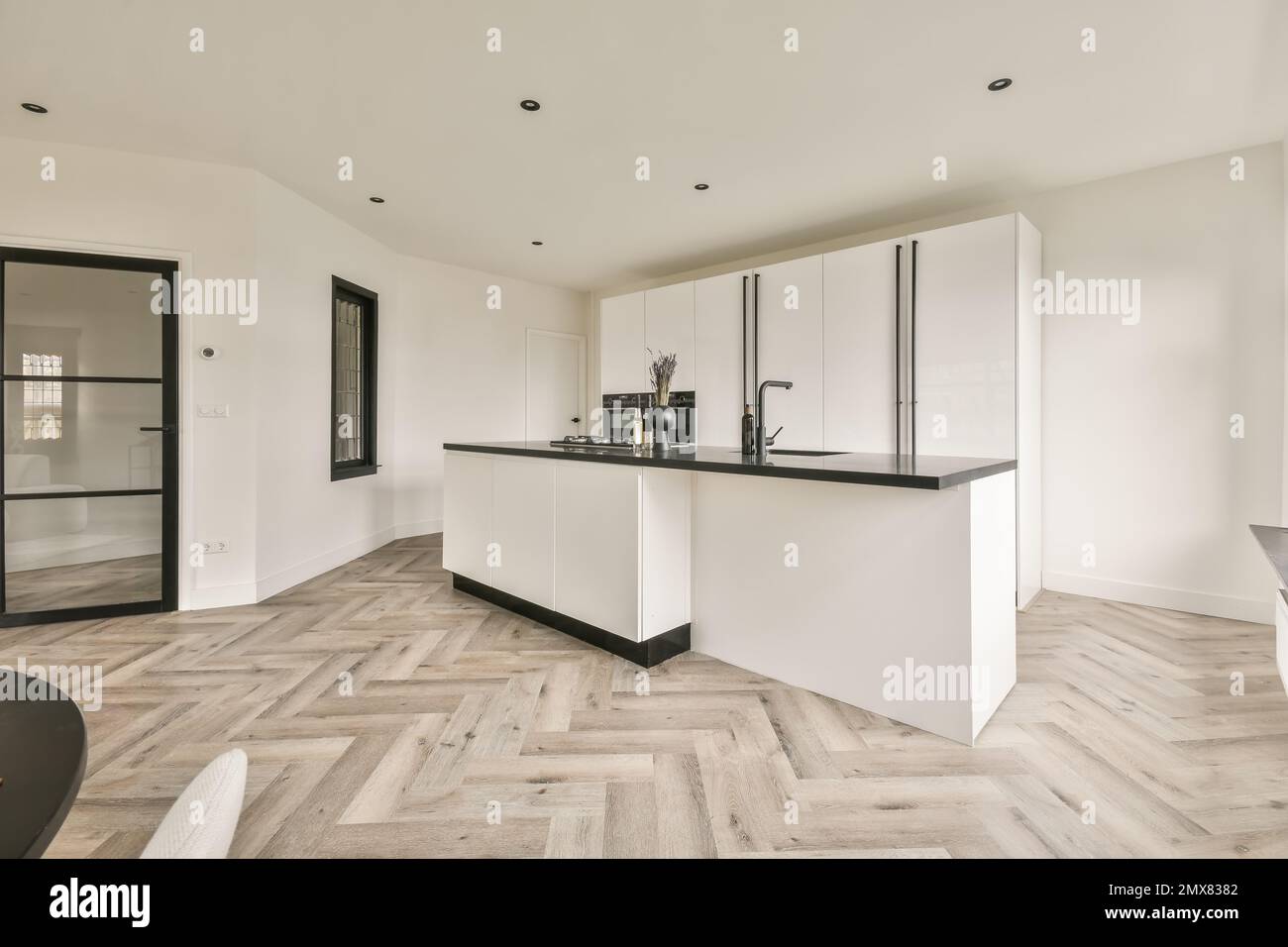Interior of modern kitchen with white cabinets and built in stove and ...
