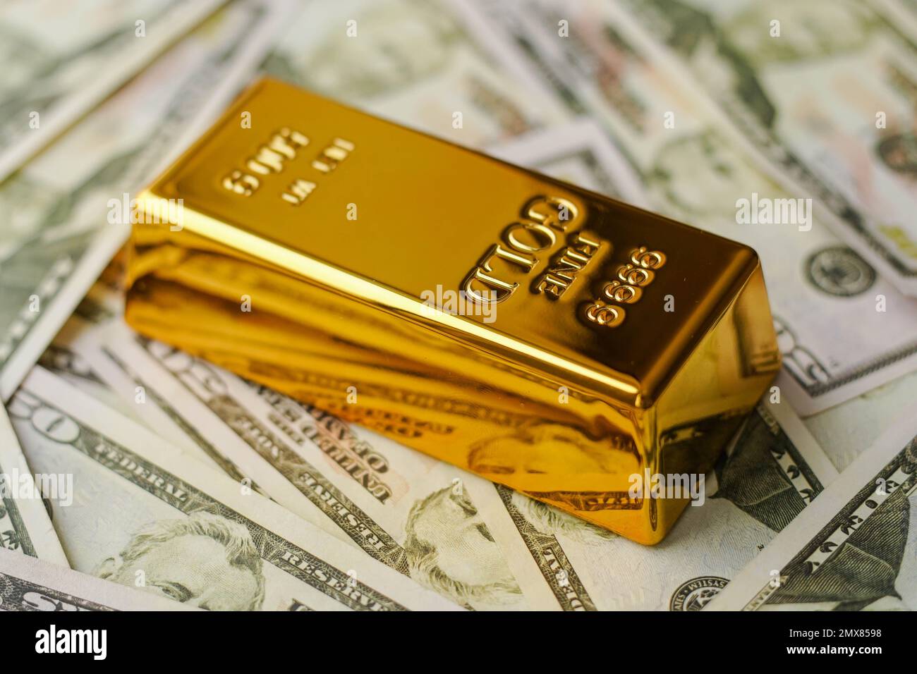 gold-bar-on-us-dollar-bill-banknotes-buying-gold-bars-for-investment-2MX8598.jpg