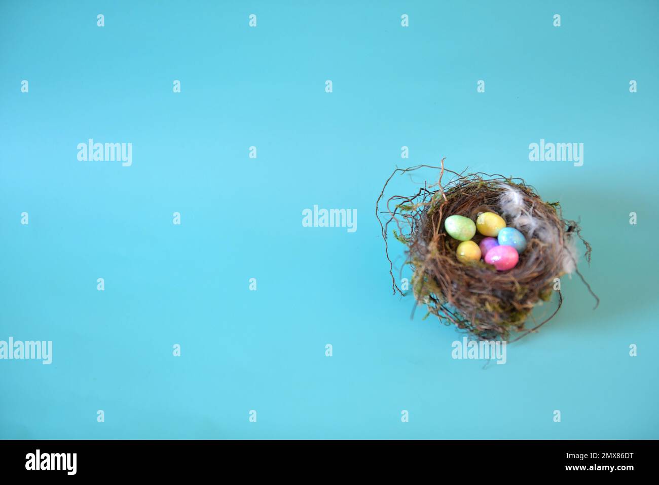 Horizontal photo of colorful Easter eggs against turquoise background.  Copy space to the left. Stock Photo