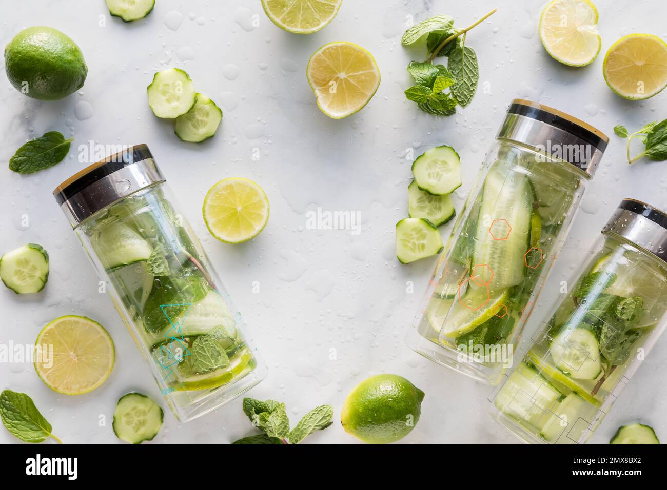 A collage of bottles of infused cucumber water with ingredients all around. Stock Photo