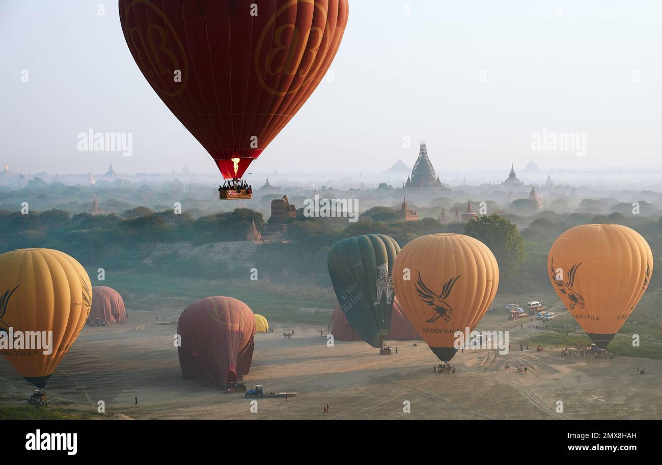 Aerial view of hot air balloons descending over ancient temples on a foggy morning in Bagan, Myanmar (Burma). Stock Photo