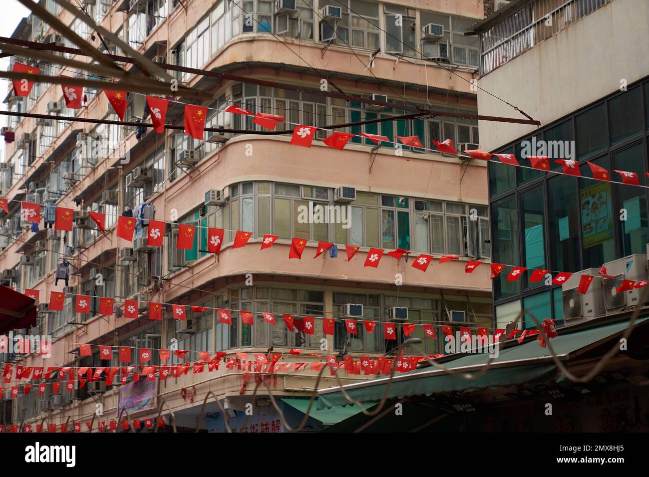 Rows of Chinese and Hong Kong flags hang over an urban street in central Hong Kong. Stock Photo
