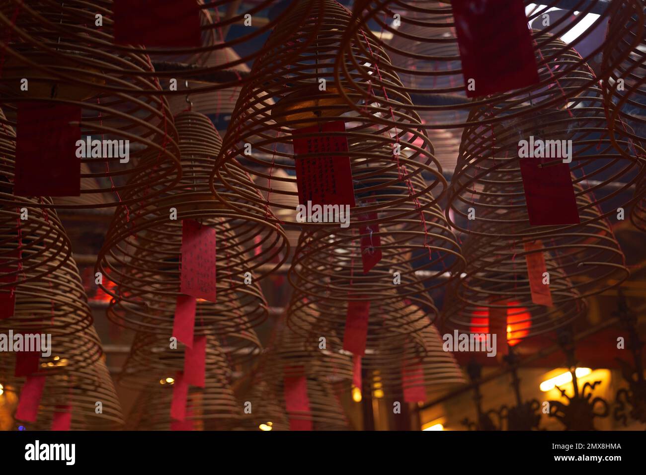 Spiral incense burning as it hangs from the rafters of a Buddhist