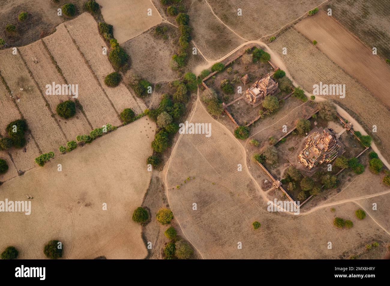 A pair of ancient temples and a dirt road in a rural landscape as viewed from above in Bagan, Myanmar (Burma). Stock Photo