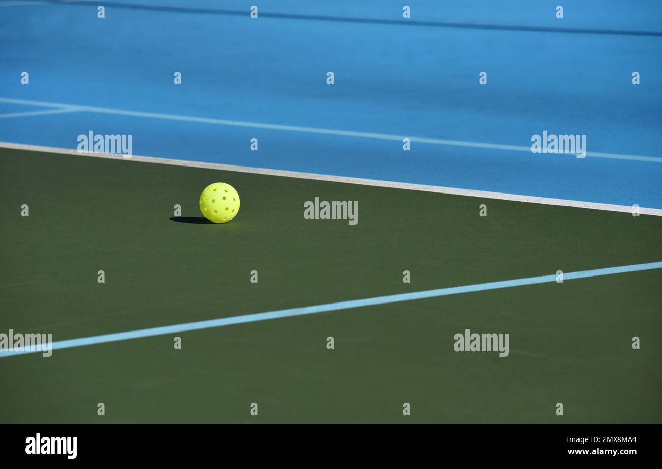 Yellow pickle ball lays on an Asheville, North Carolina, tennis court