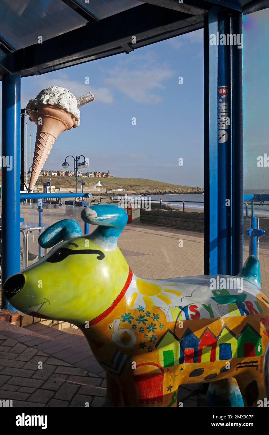 Giant ice cream cone sign and amusing multicoloured dog sculpture. at