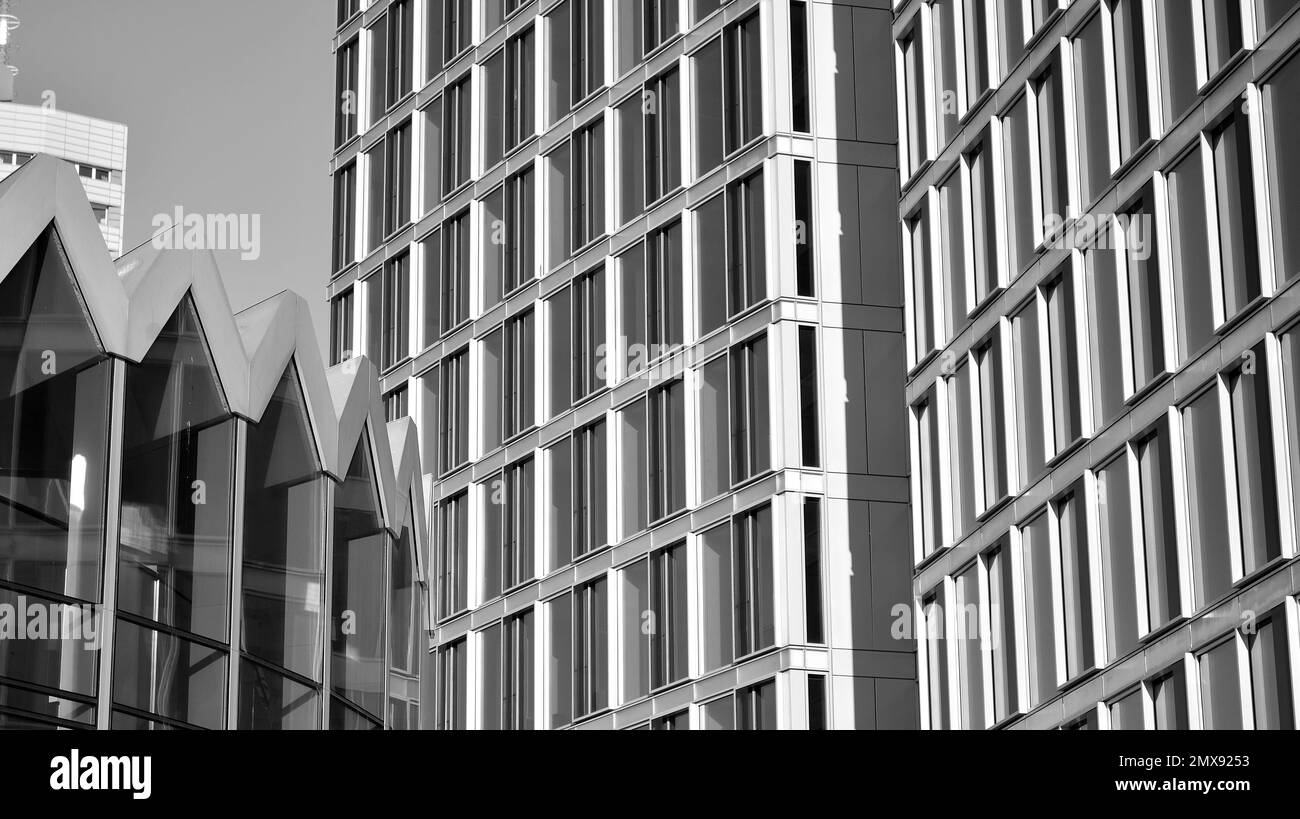 Commercial building close up in blue tone. Gigantic skyscraper from below. Architecture details of modern building amd glass facade. Black and white. Stock Photo