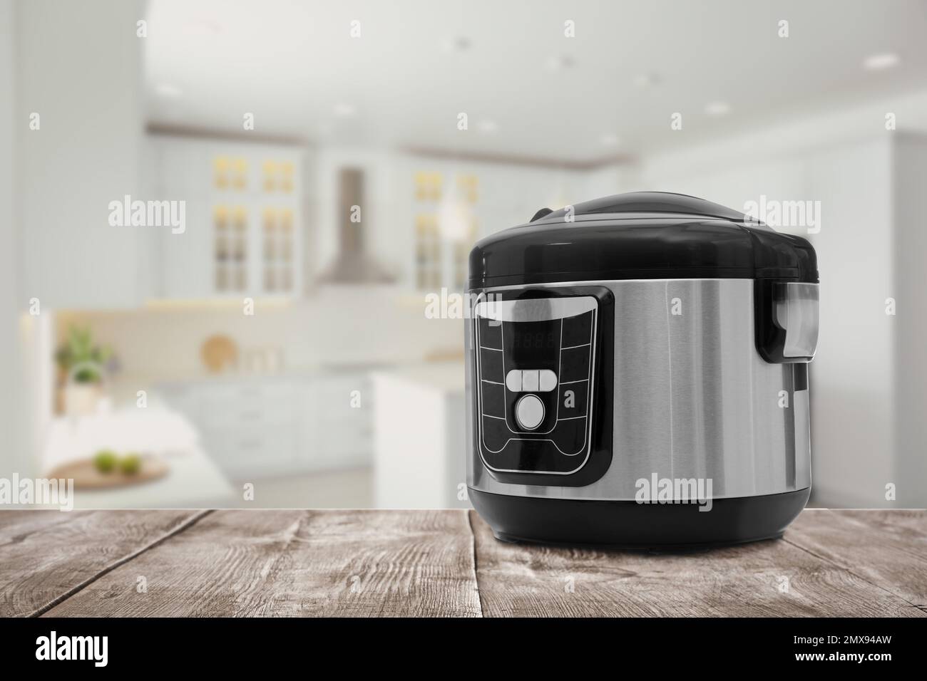 Table Cooker Electric Modern electric multi cooker on wooden table in kitchen. Space for ...