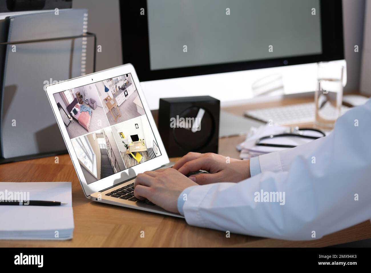 Man monitoring modern cctv cameras on laptop indoors, closeup. Home