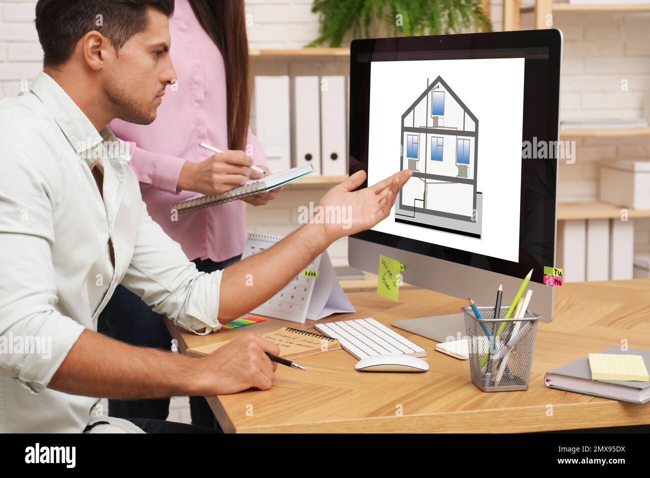 Engineers at work. Colleagues projecting house in office Stock Photo
