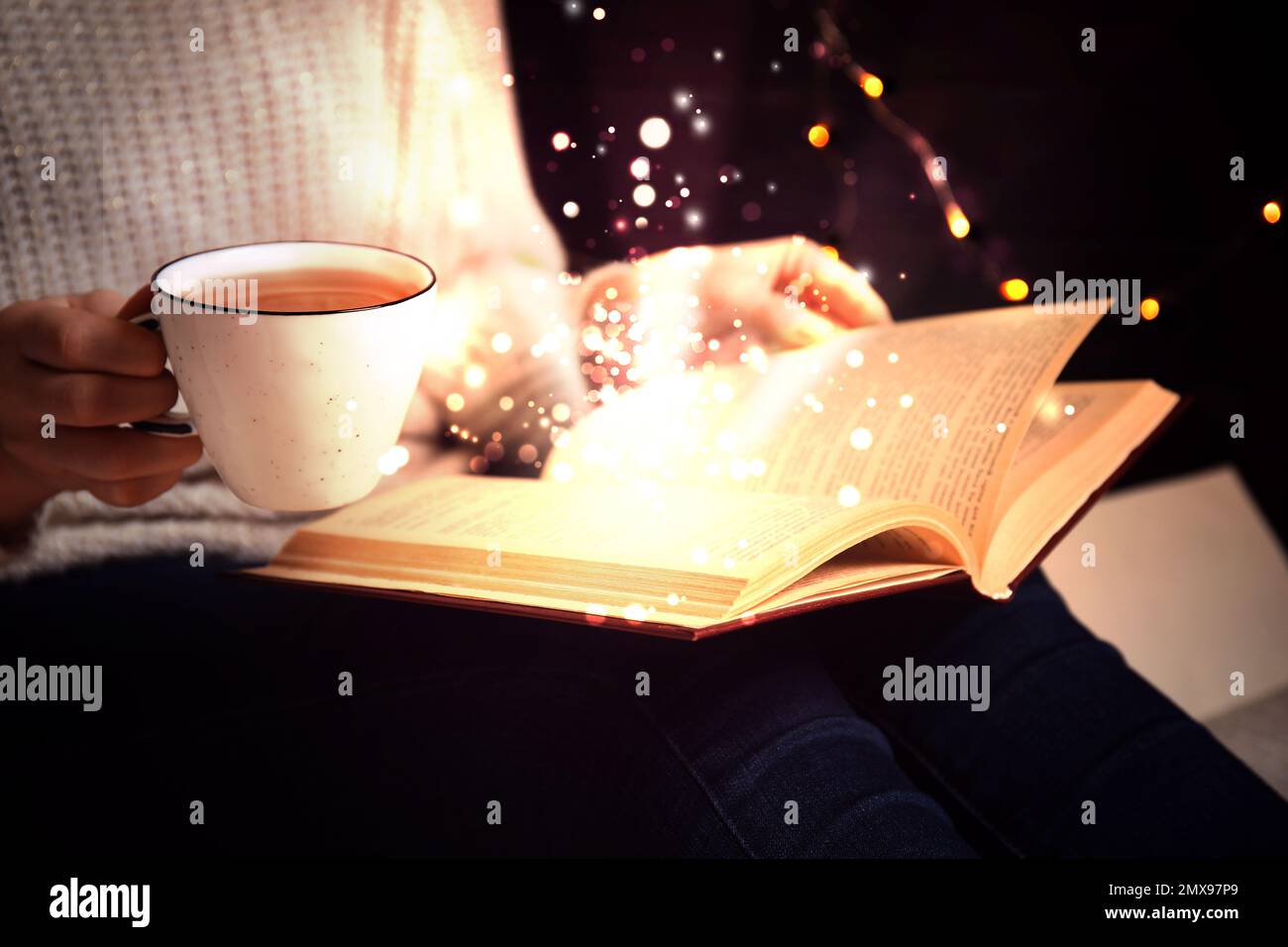 Woman reading shiny magic book, closeup view Stock Photo