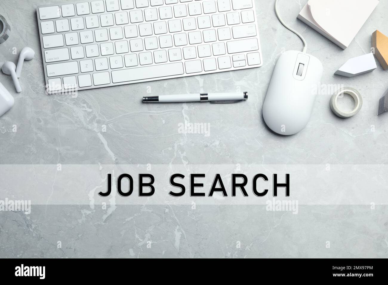 Flat lay composition with computer mouse and keyboard on light grey marble table. Job search Stock Photo