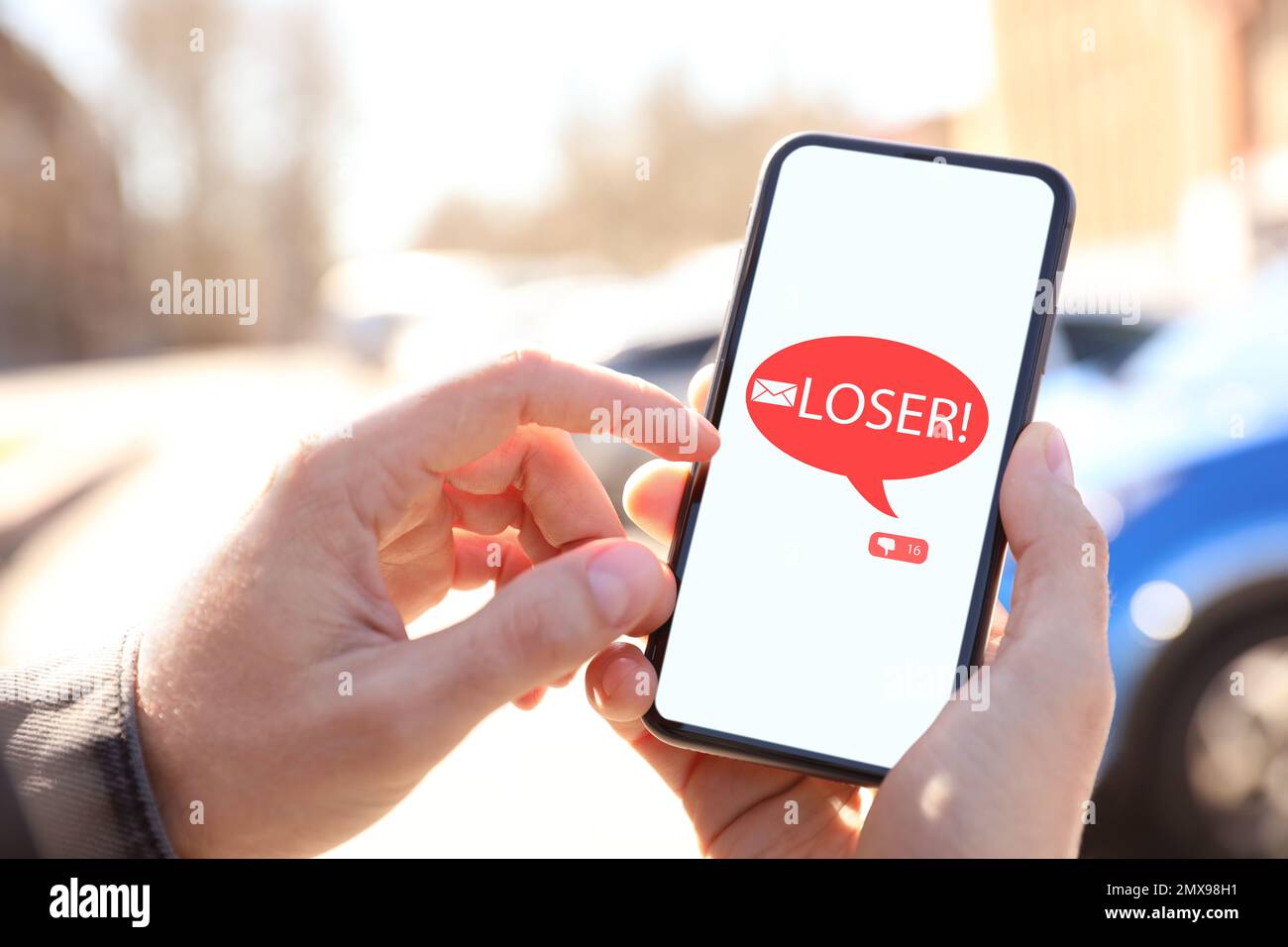 Man receiving offensive message with text LOSER!, closeup. Cyber bullying concept Stock Photo