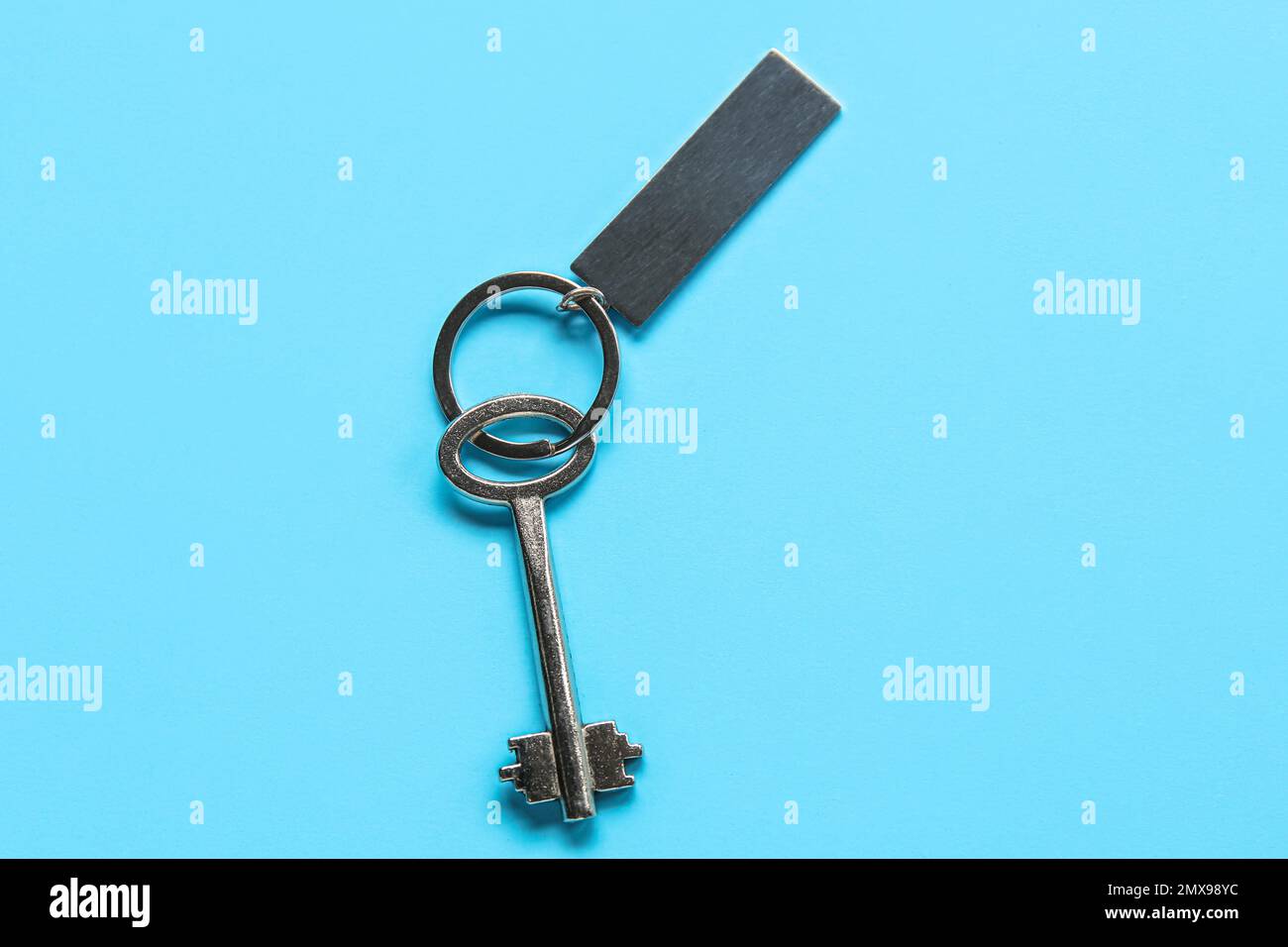 Key with metallic keychain on color background Stock Photo