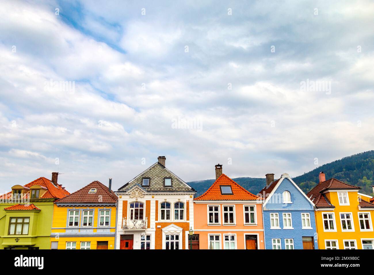 Colourful Norwegian houses against the sky and mountains in Nøstet neighbourhood, Bergen, Norway Stock Photo