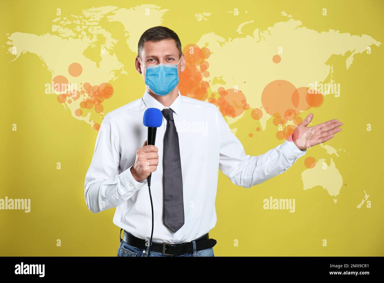 Journalist with medical mask presenting news during coronavirus outbreak. World map demonstrating spread of disease Stock Photo