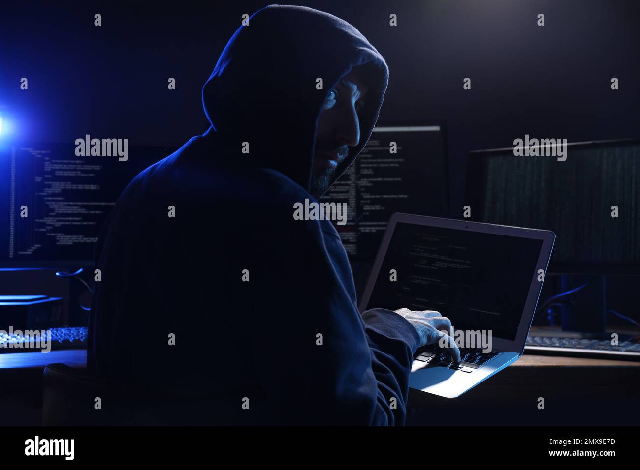 Hacker with computers in dark room. Cyber crime Stock Photo