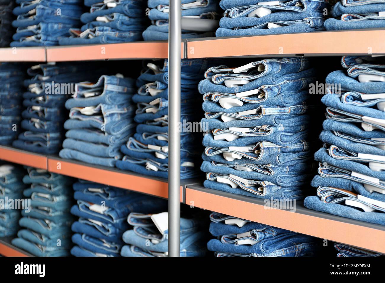 Collection of stylish jeans on shelves in shop Stock Photo Alamy