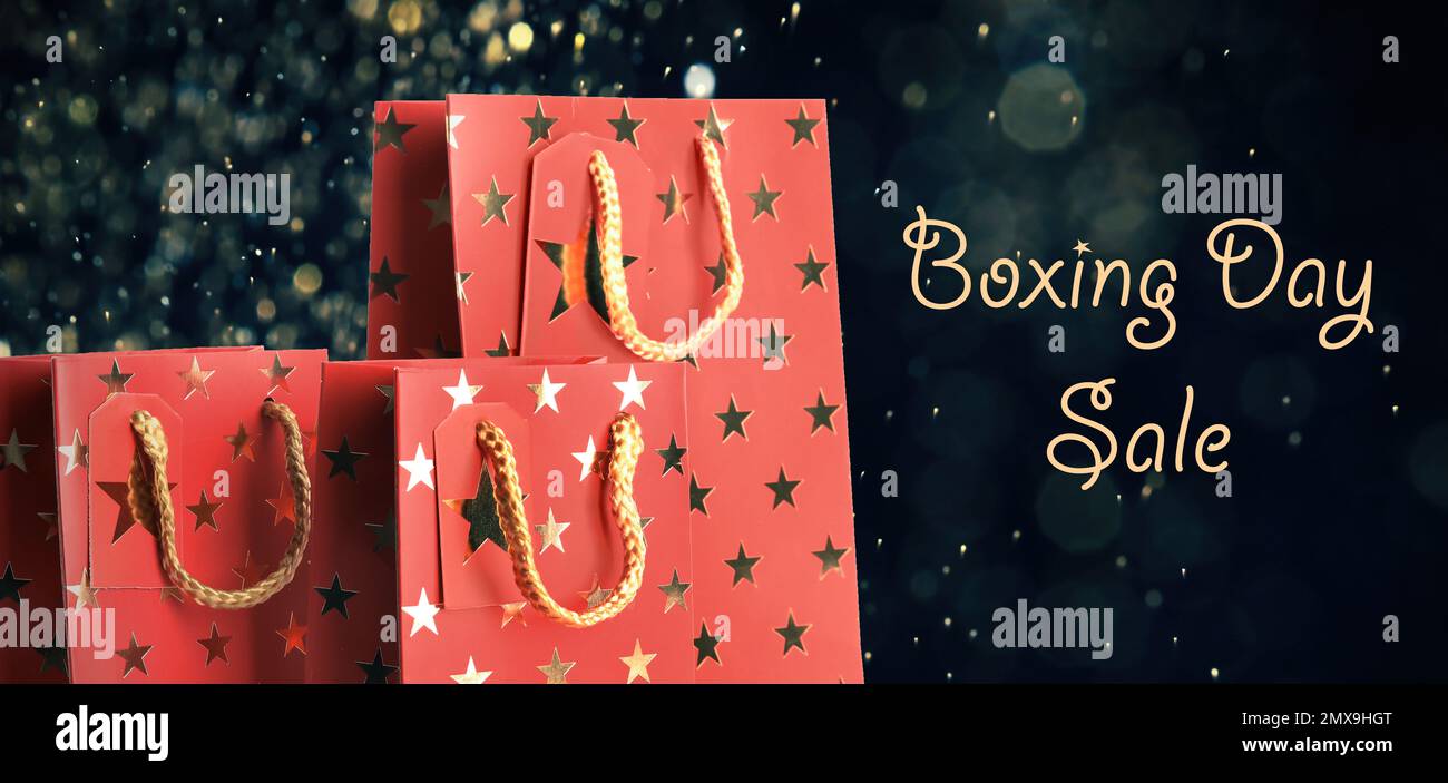 Boxing day sale. Shopping bags and blurred lights on dark background