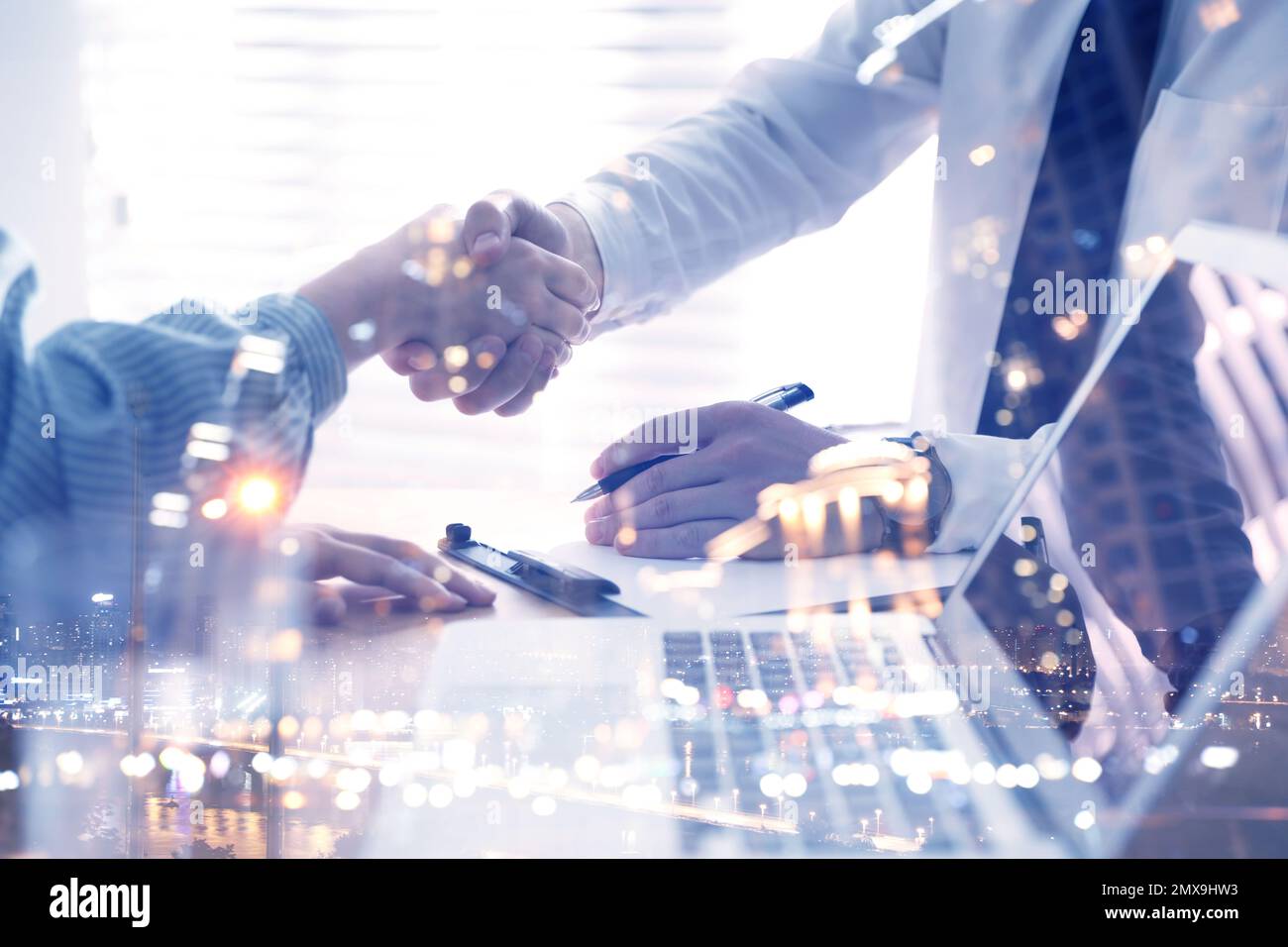 Business people shaking hands and night cityscape, closeup. Multiple exposure Stock Photo