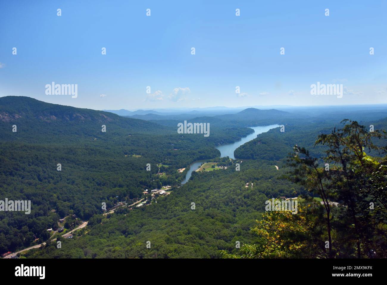 View of distant Lake Lure and the Smokey Mountains of North Carolina.  Highway 64 can also be seen.  High view from Chimney Rock at Chimney Rock State Stock Photo