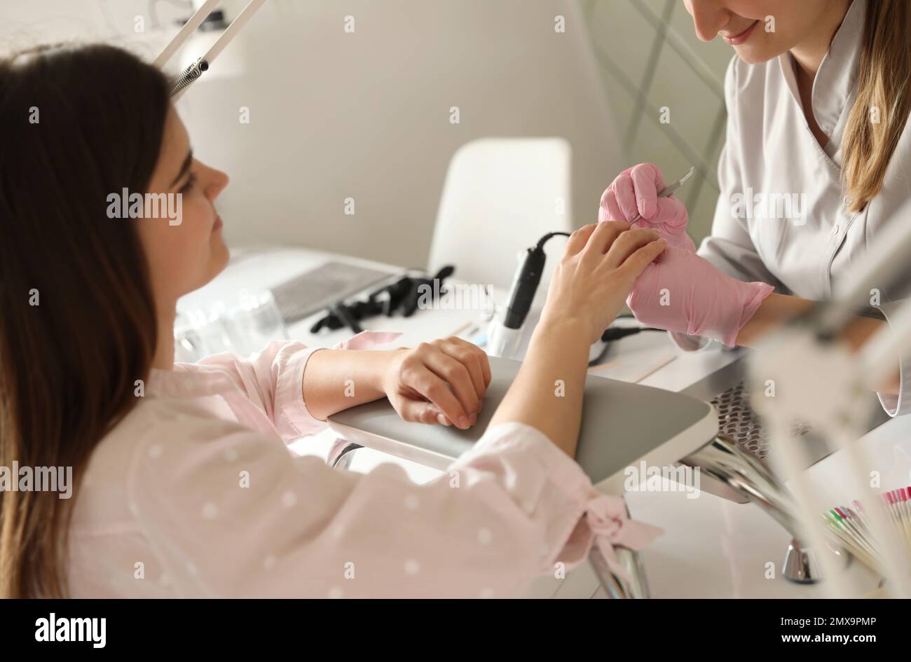 Professional manicurist working with client in beauty salon Stock Photo ...