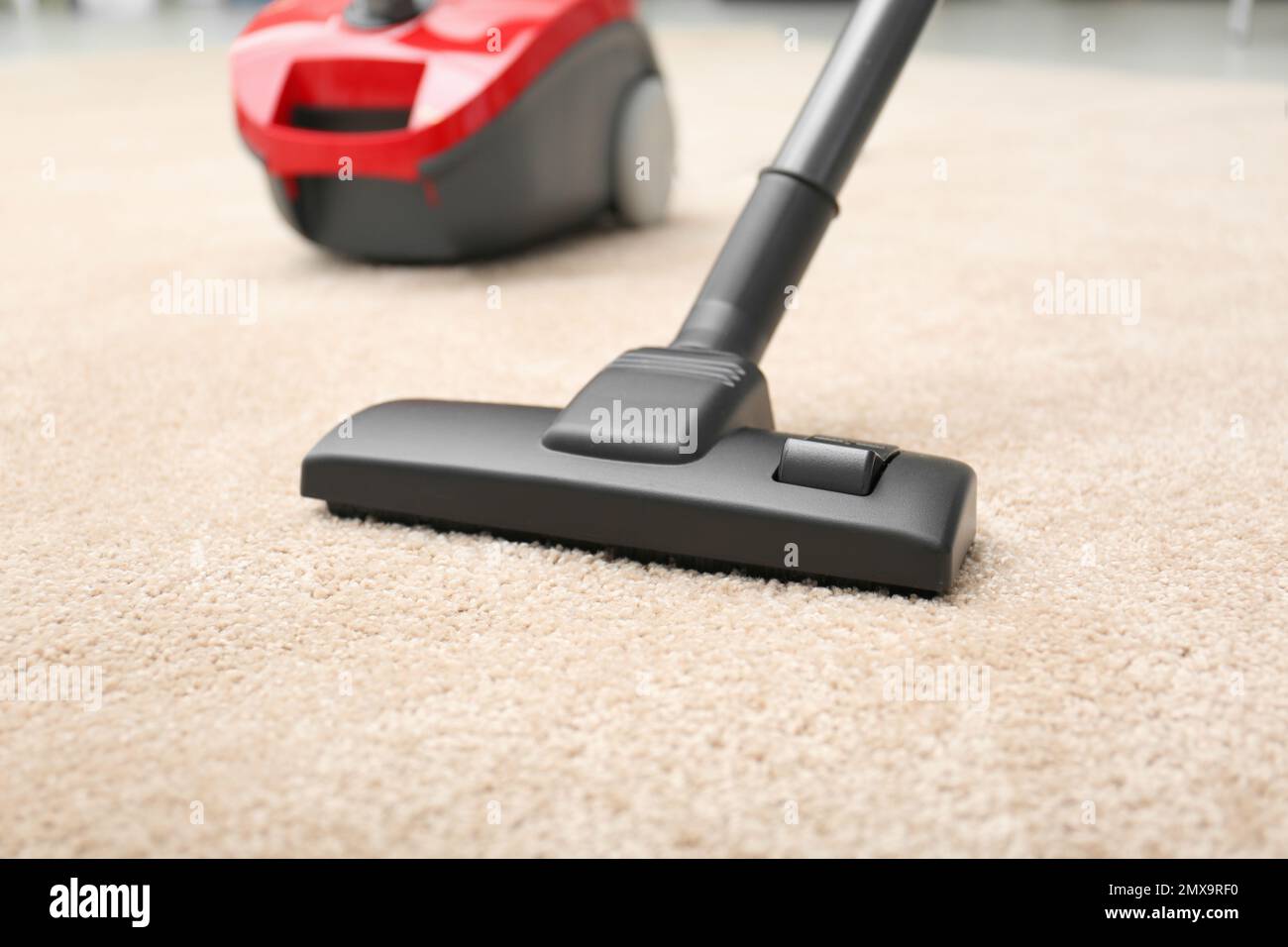Removing dirt from carpet with modern vacuum cleaner indoors Stock
