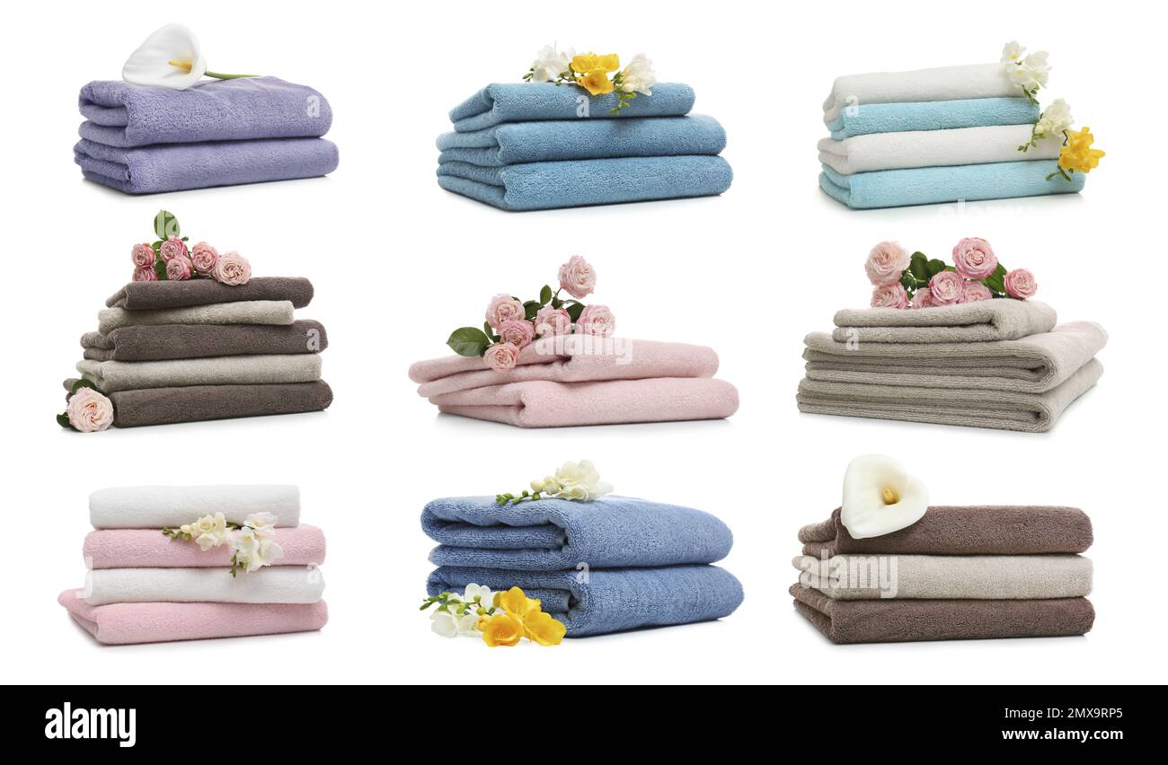 Set of folded soft terry towels and flowers on white background Stock Photo