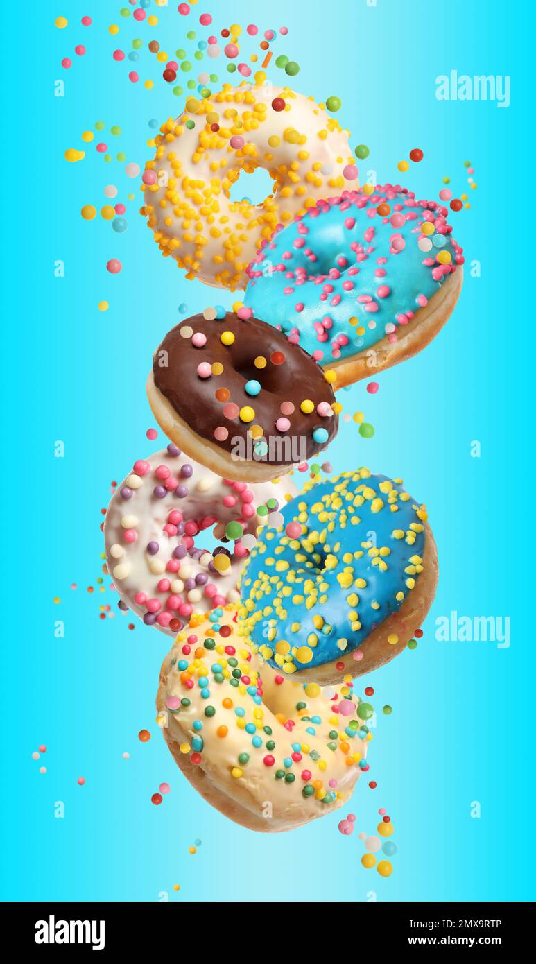Set of falling delicious donuts on light blue background Stock Photo ...