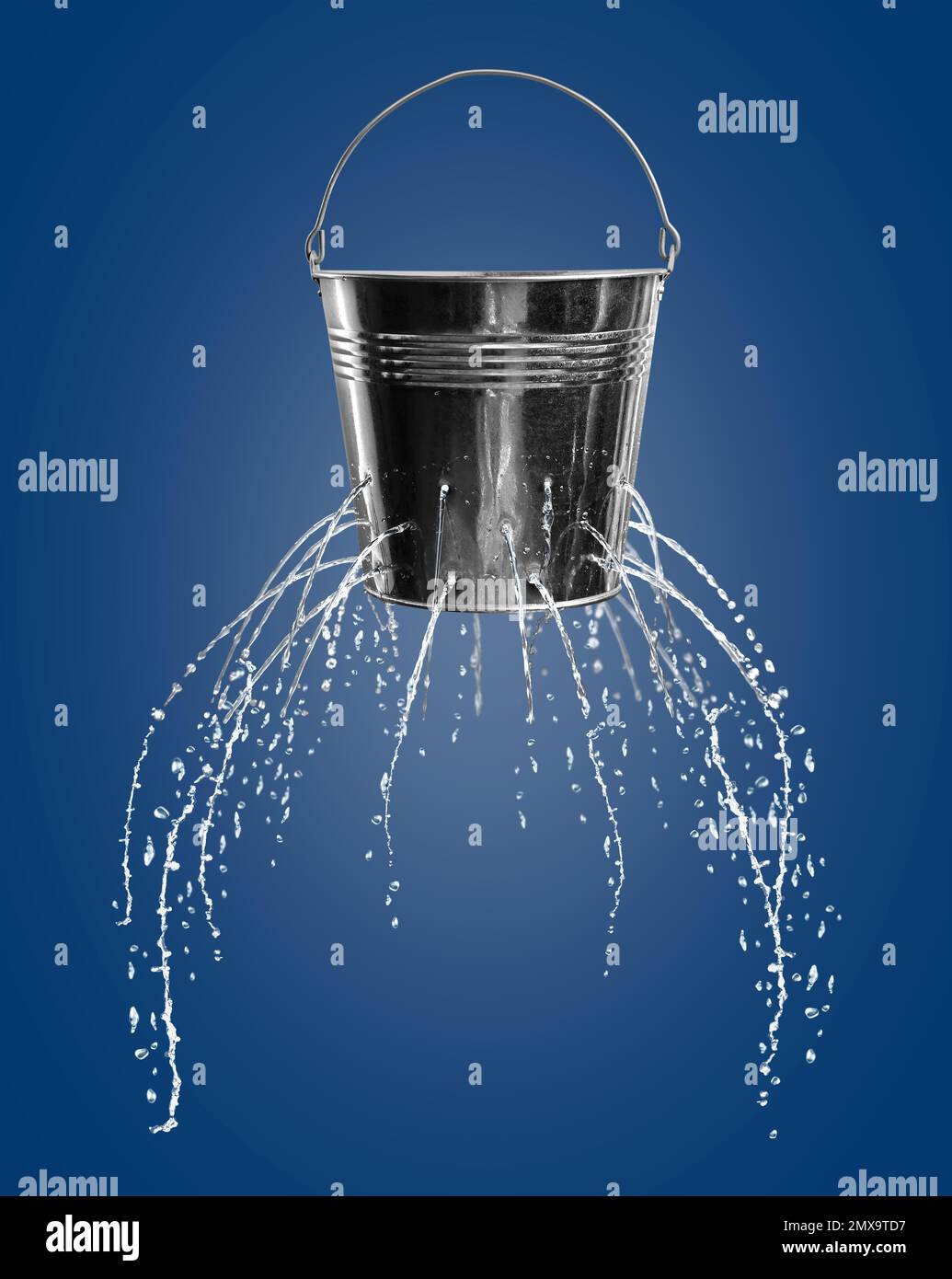 Leaky bucket with water on blue background Stock Photo Alamy