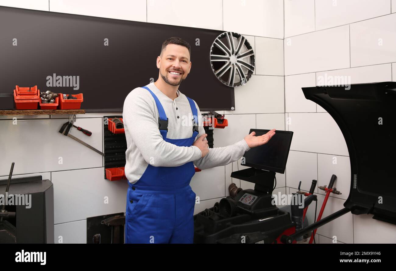 Mechanic near wheel balancing machine at tire service Stock Photo Alamy