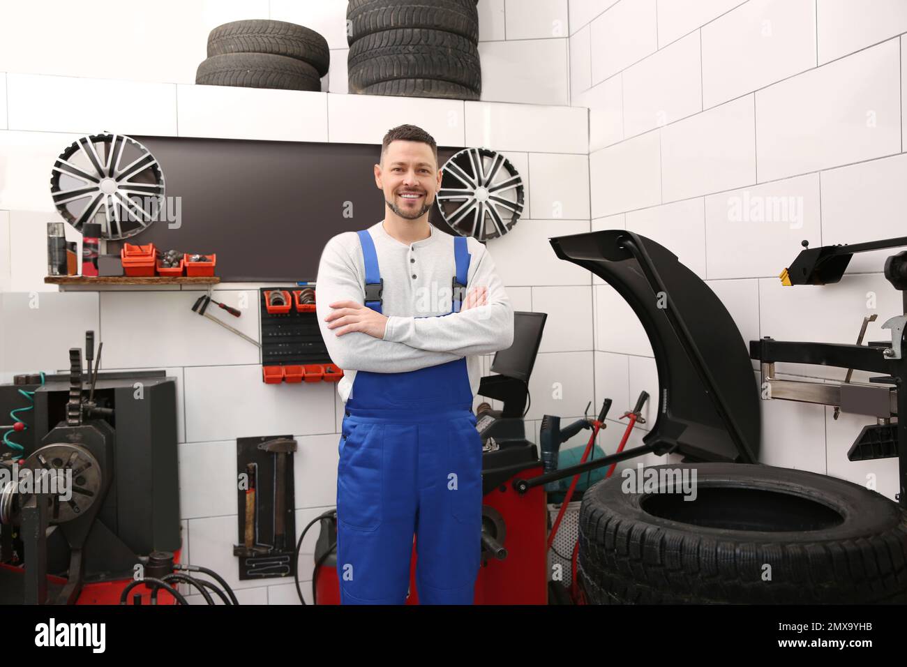 Mechanic near wheel balancing machine at tire service Stock Photo Alamy
