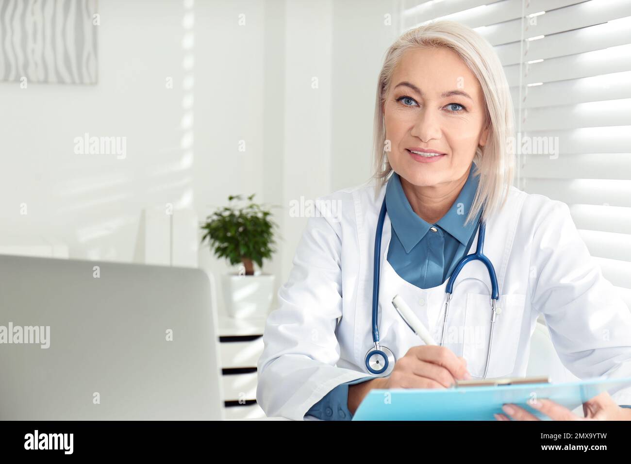Mature doctor sitting workplace hi-res stock photography and images - Alamy