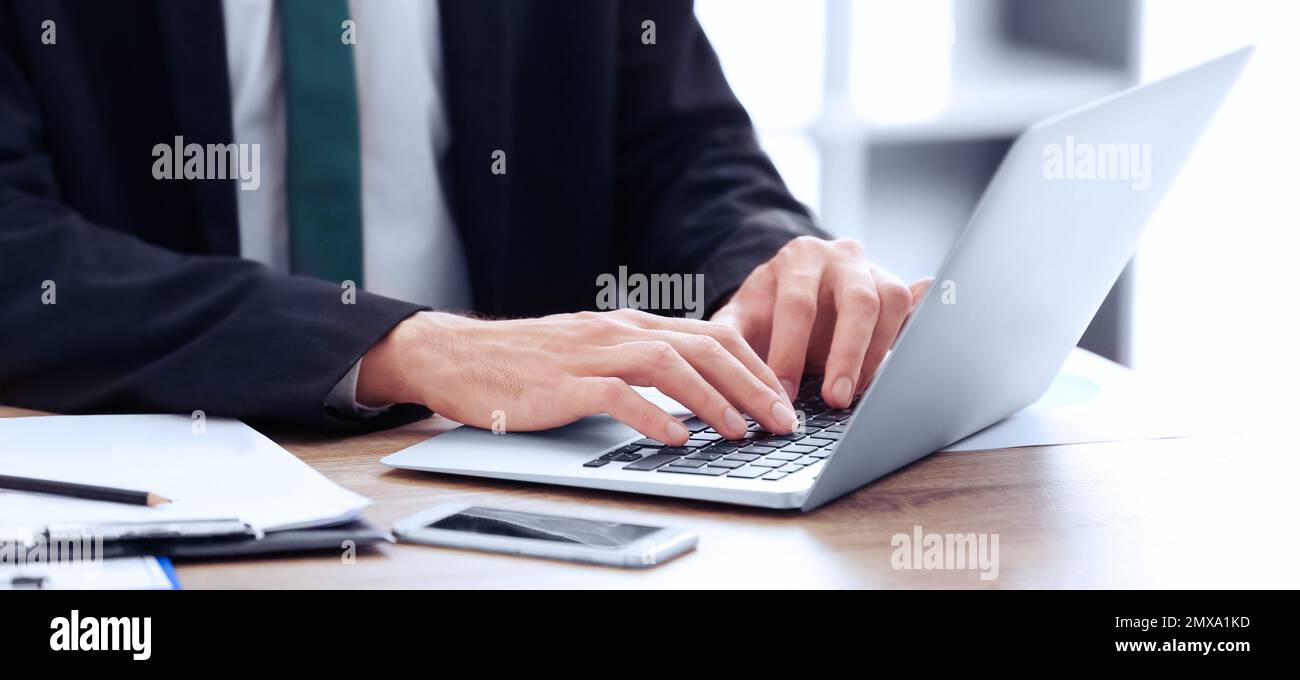 Man working on computer at table in office, closeup. Banner design Stock Photo