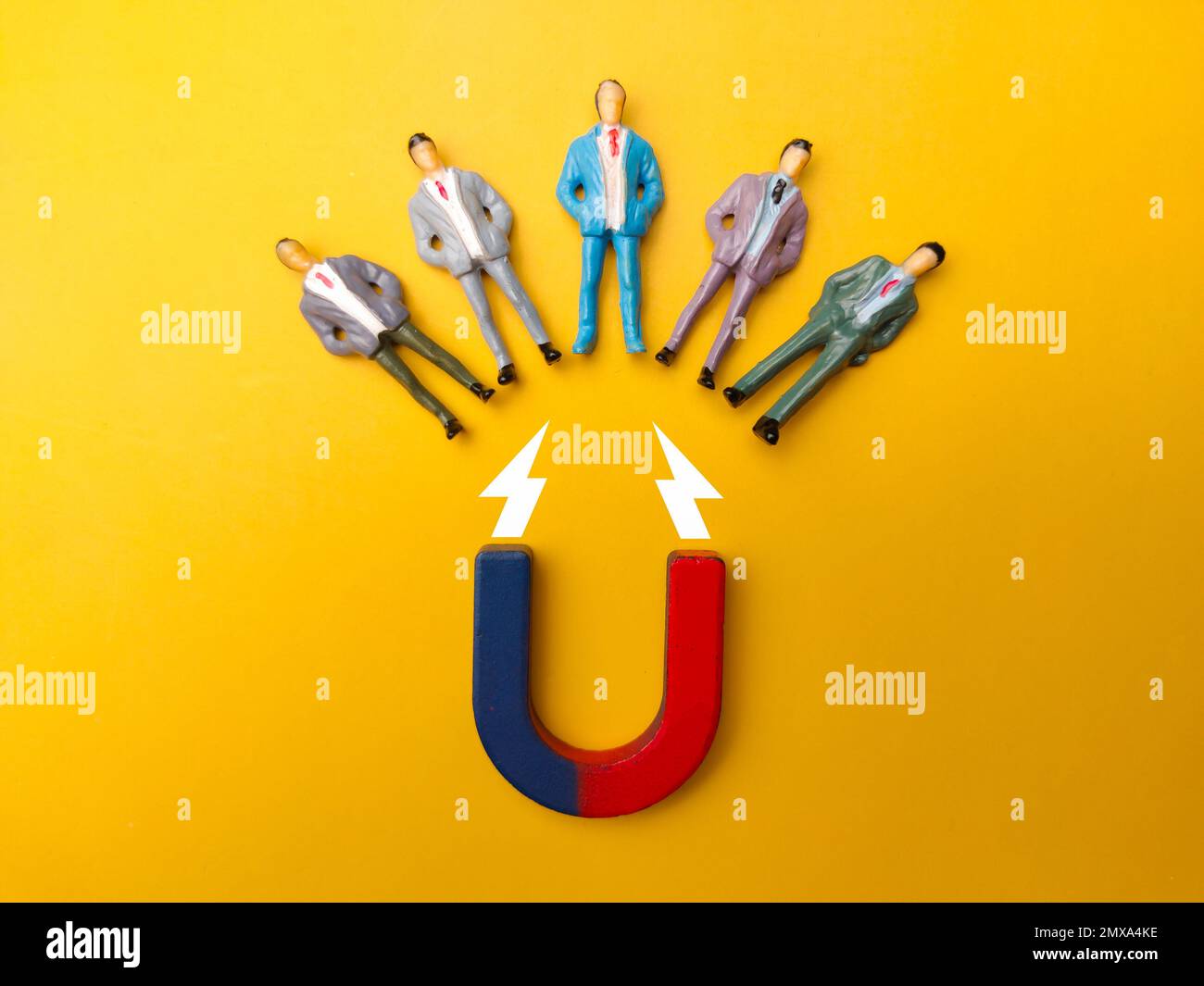 Businessman attracts by magnet on a yellow background. Business and leadership concept. Stock Photo