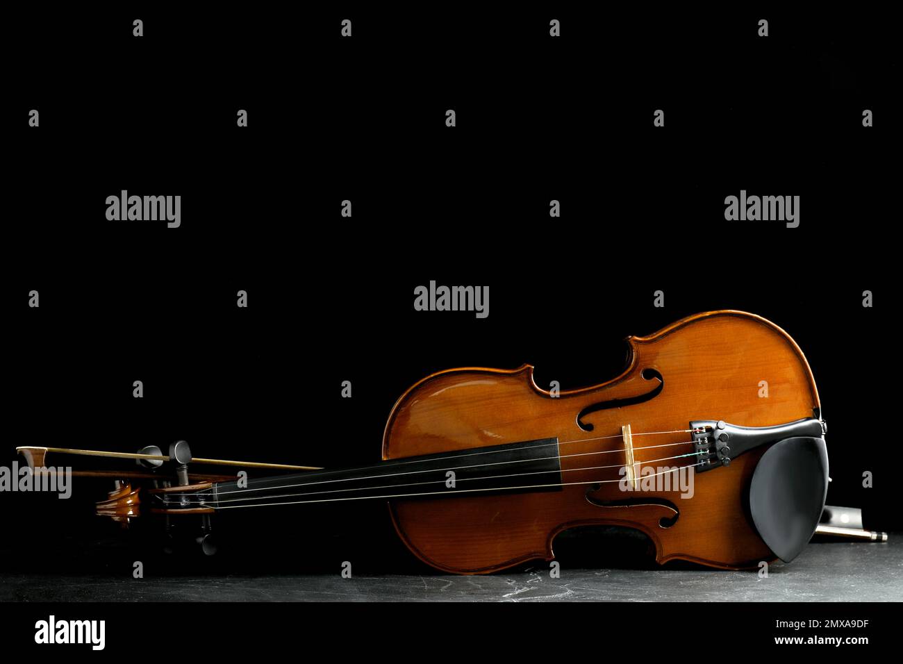 Classic violin and bow on grey stone table. Space for text Stock Photo