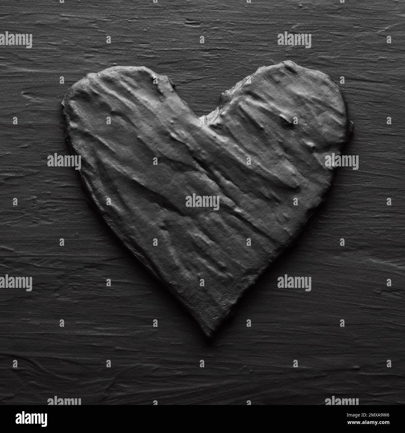 Dark black heart on rough slate like bakcground Stock Photo
