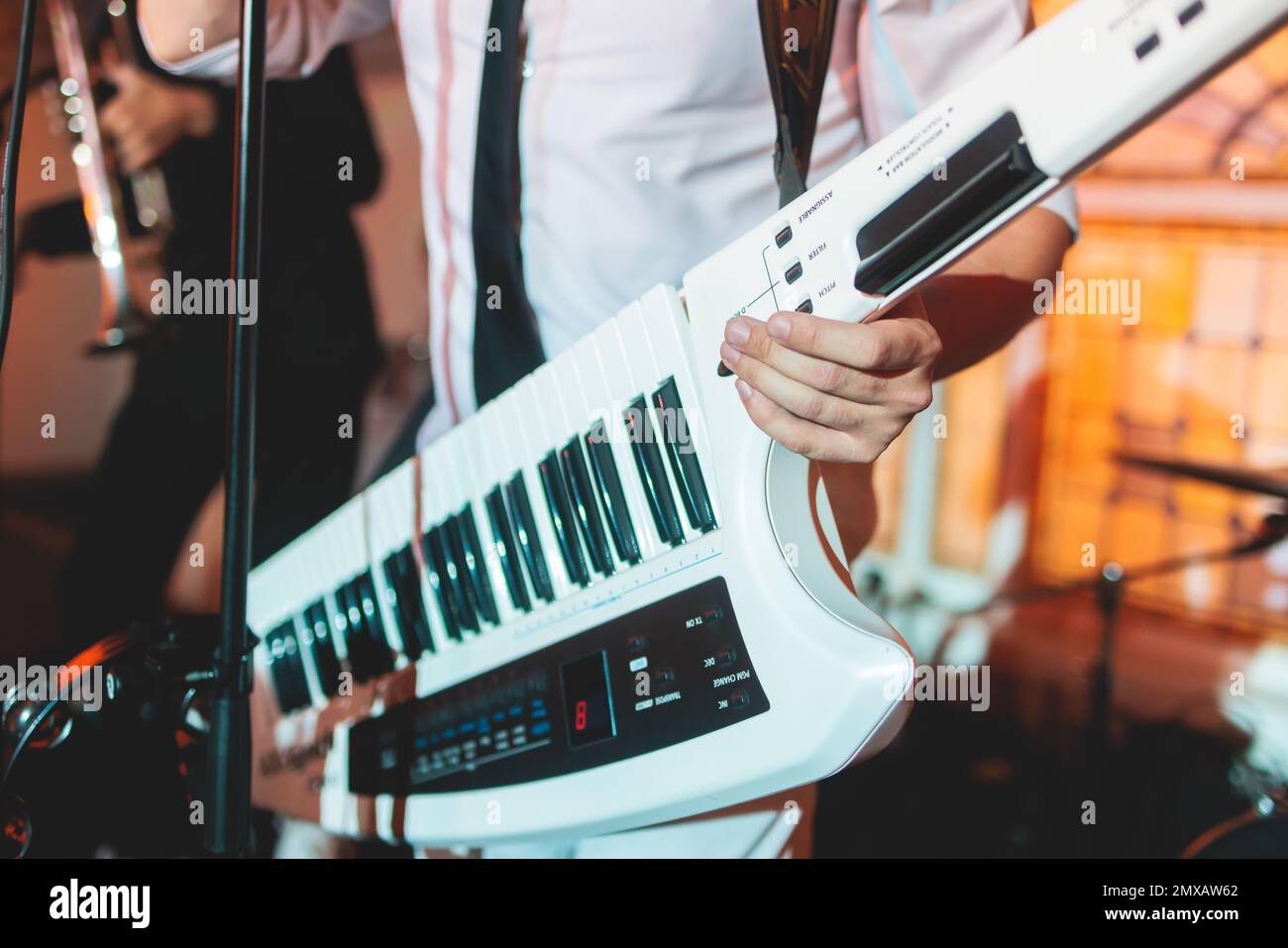 Concert view of a keytar synthesizer player with vocalist and musical jazz  rock band orchestra performing in a background, electronic keyboard instrum  Stock Photo - Alamy