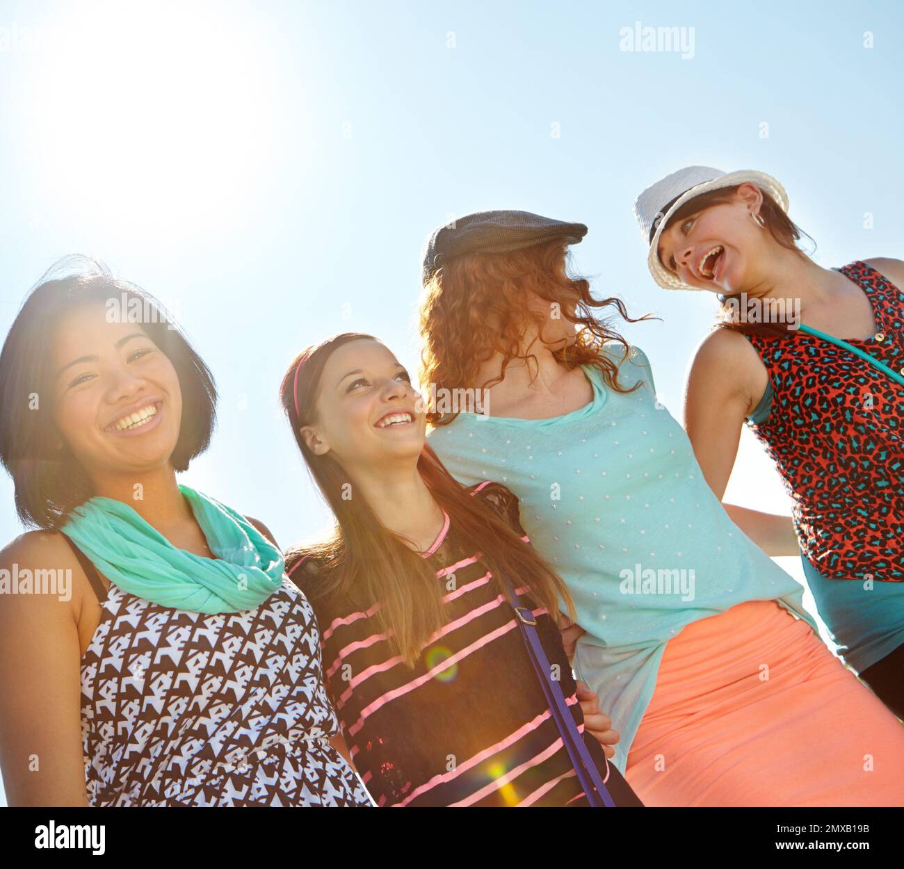 Summertime fun with the girls. Low-angle view of a group of teeange girls walking outside with their arms entwined. Stock Photo