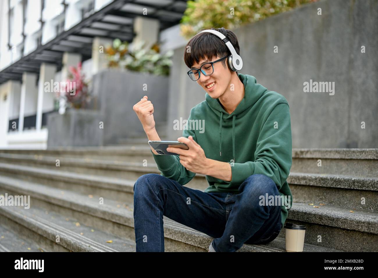 Cheerful young Asian male college student in casual clothes wearing ...