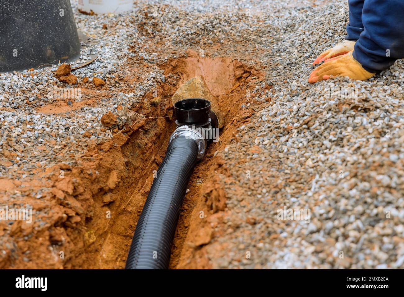 Putting drainage pipe for rain water on gravel sidewalk of car parking lot where parking lot Stock Photo