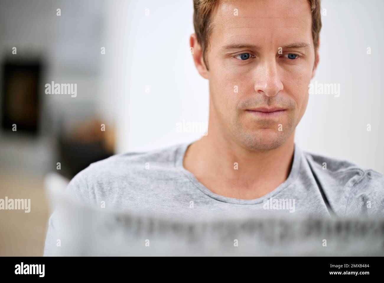 Catching up on current affairs. a handsome man reading a newspaper at home. Stock Photo