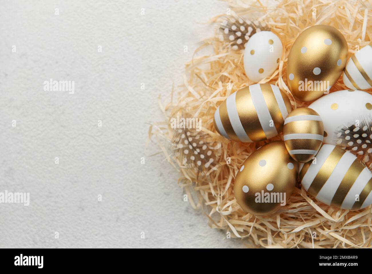 Easter eggs painted with gold paint on a straw background. Concept of ...