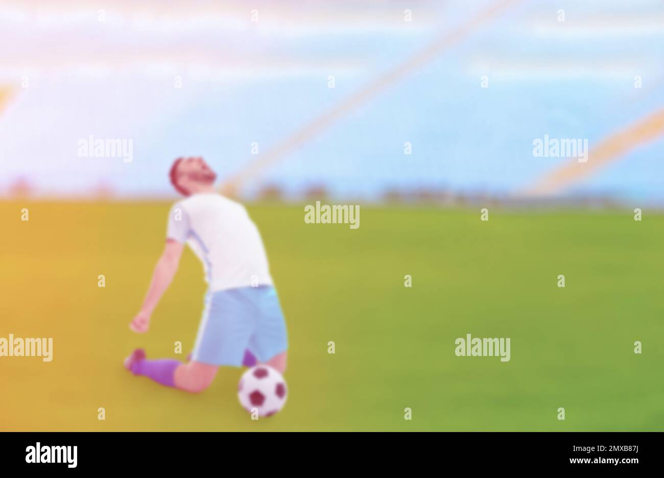 Blurred view of young man playing football at stadium, space for text