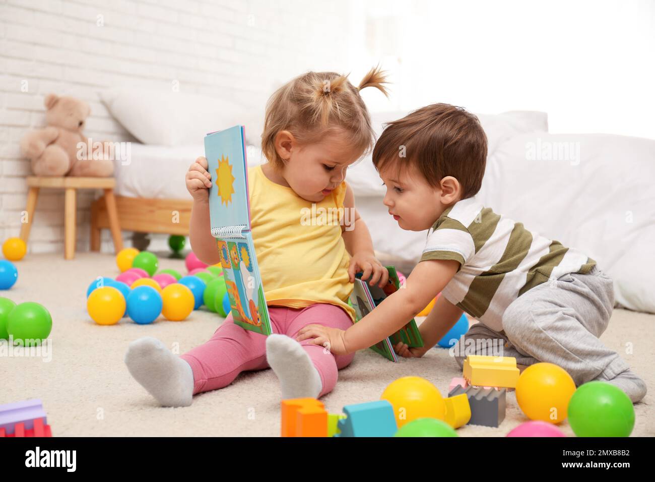 Cute little children playing with toys on floor at home Stock Photo - Alamy