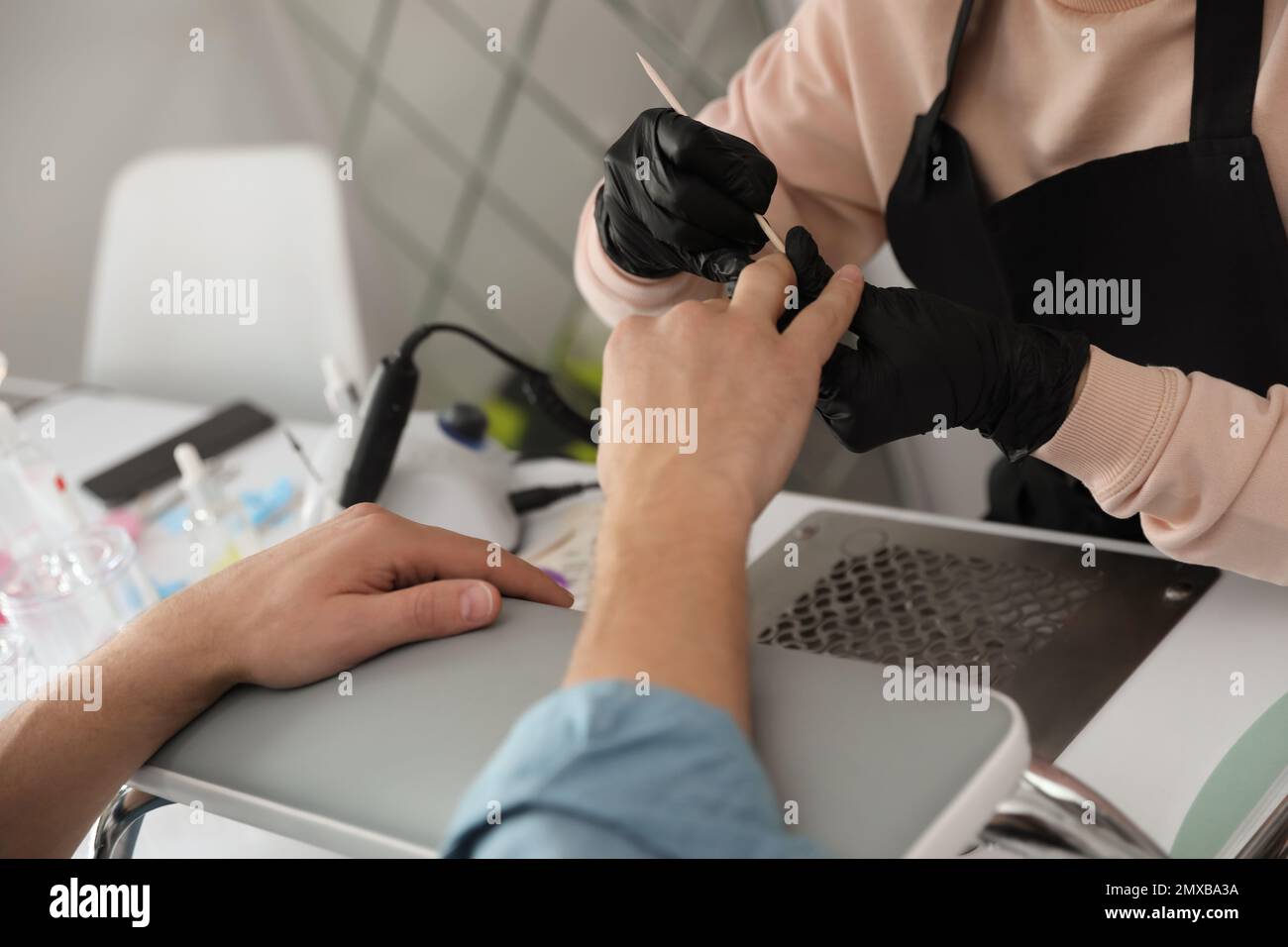 Professional manicurist working with client in beauty salon, closeup ...