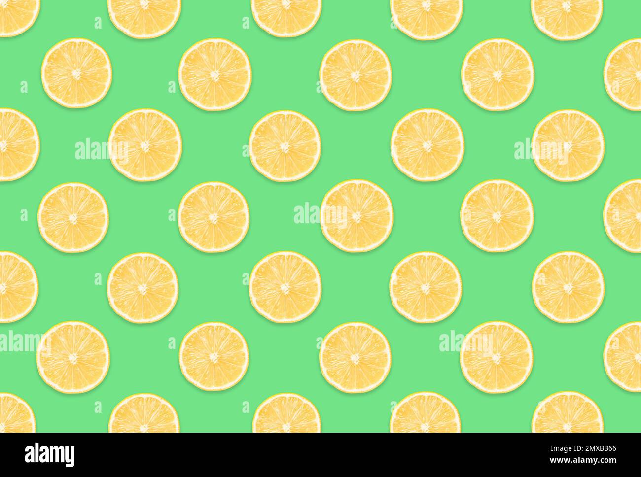 Pattern of lemon slices on light green background Stock Photo