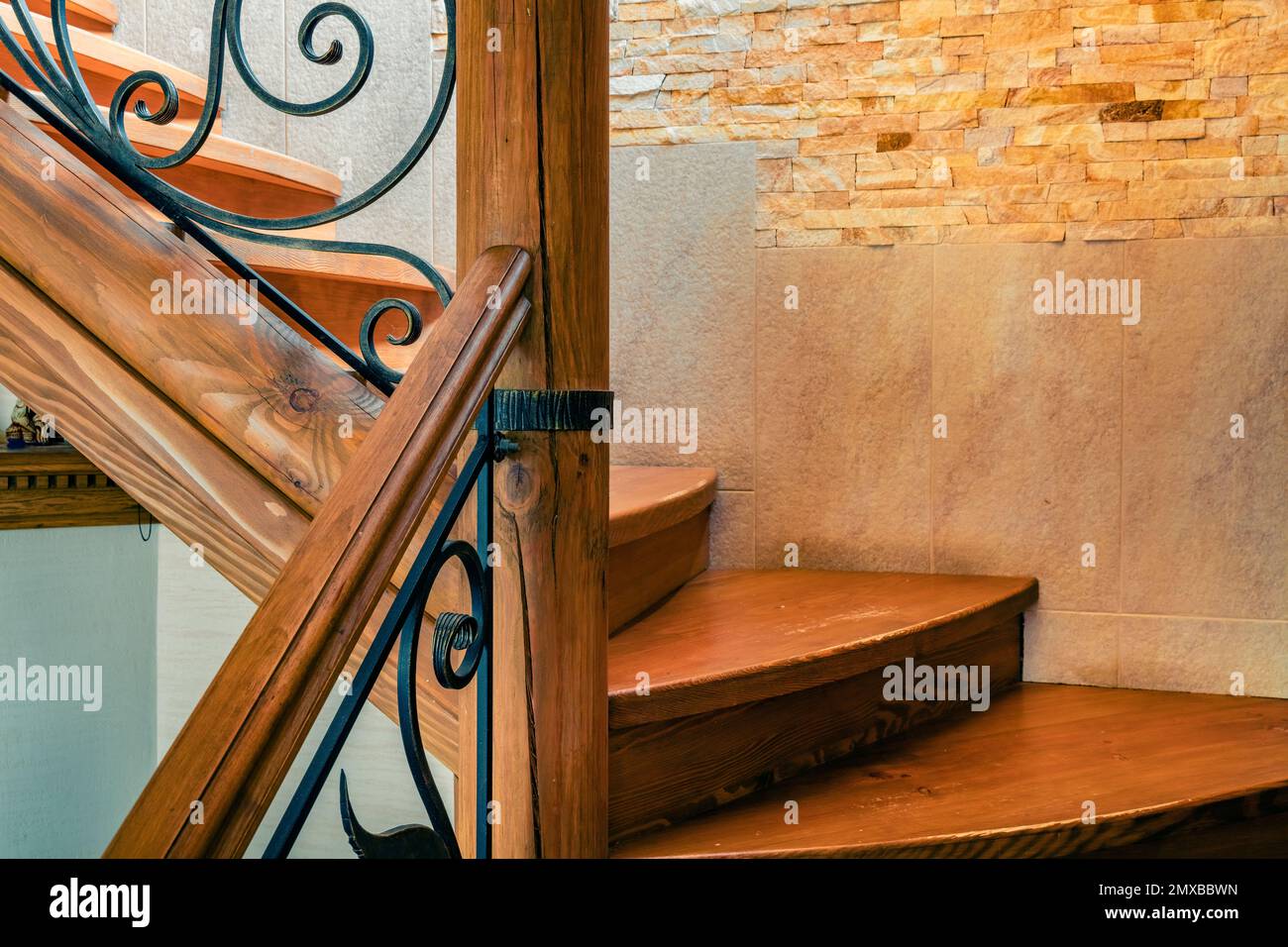 Elements of wrought iron railings and wooden stairs in a mountain chalet in the Carpathians. Stock Photo