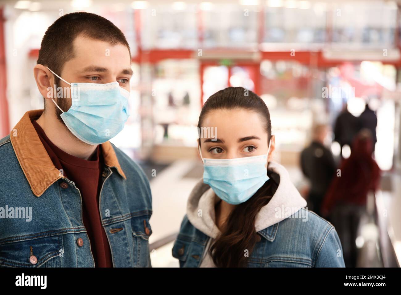 Couple wearing disposable masks in mall. Dangerous virus Stock Photo Alamy