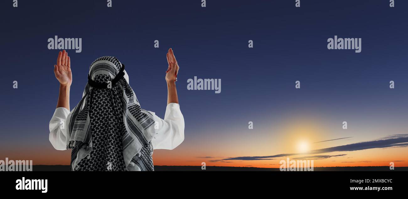 Muslim man praying outdoors at sunset. Banner design Stock Photo